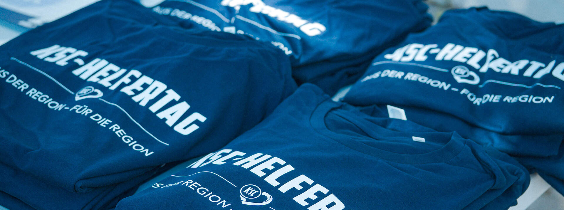 T-Shirts vom KSC-Helfertag ausgebreitet auf einem Tisch.